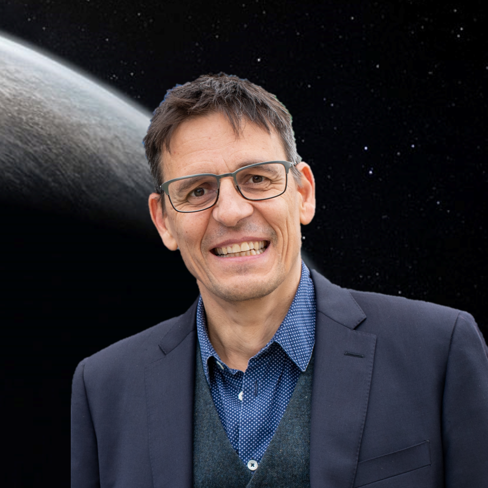 Smiling middle-aged man with glasses and dark blazer, posed against a space background with a planet and stars.
